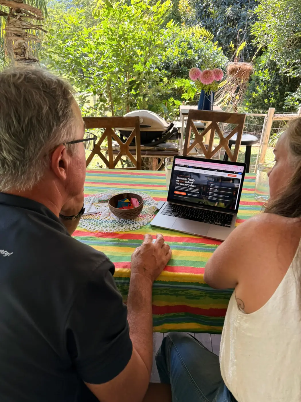 Two people looking over a website together at an outdoor table